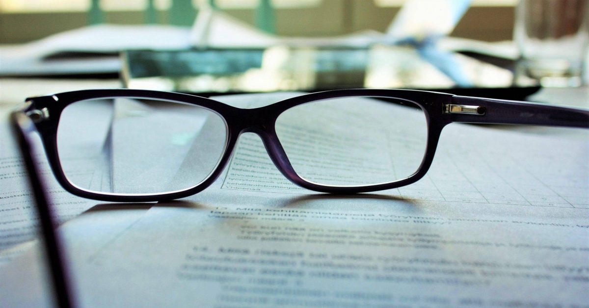 black-framed eyeglasses on white printing paper
