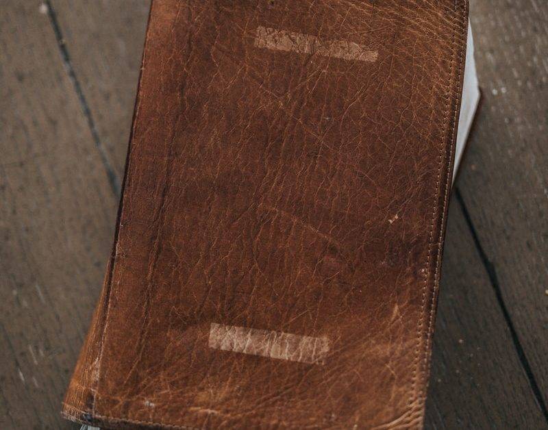 brown leather bifold wallet on brown wooden table
