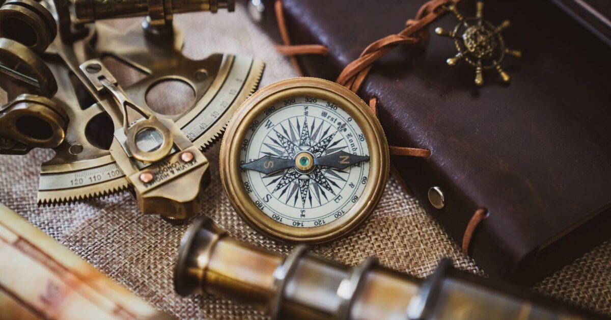 silver and gold compass on black leather textile
