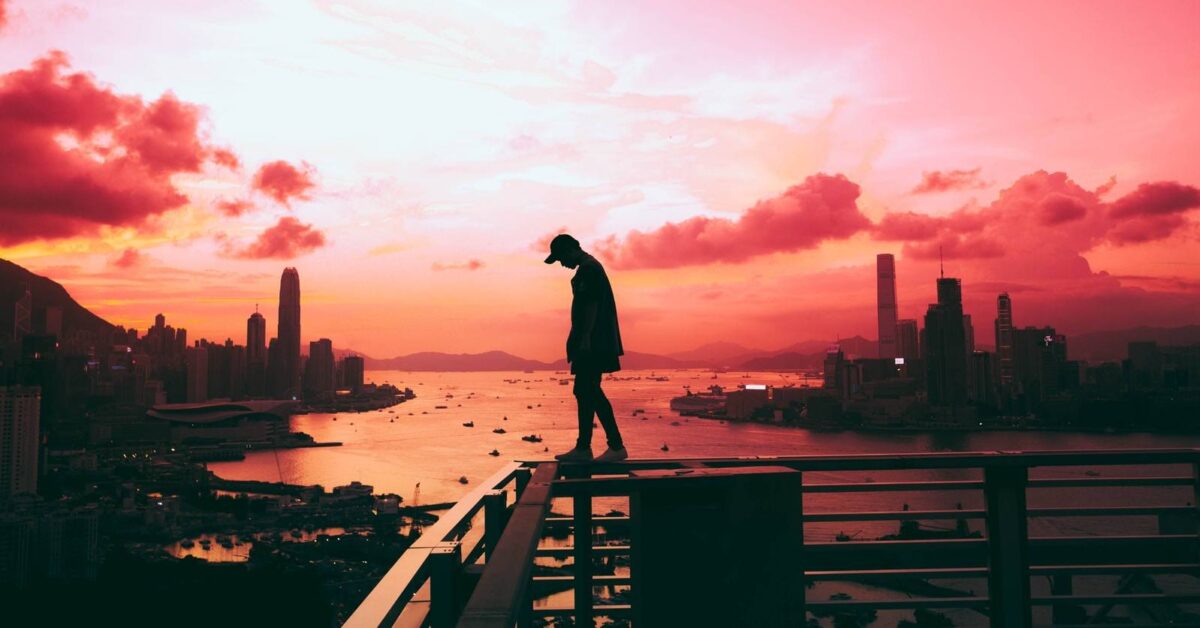 silhouette of person standing on railing